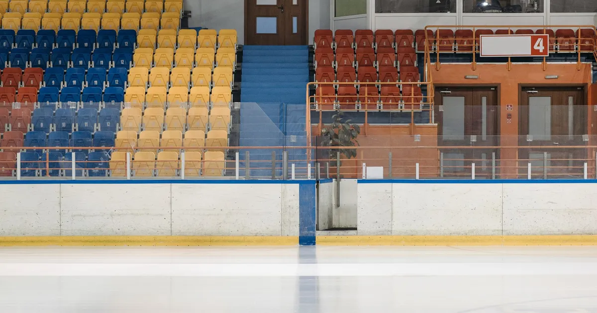 Patinoire intérieure vide avec gradins colorés, symbole des salles de glace des Jeux d'hiver 2030